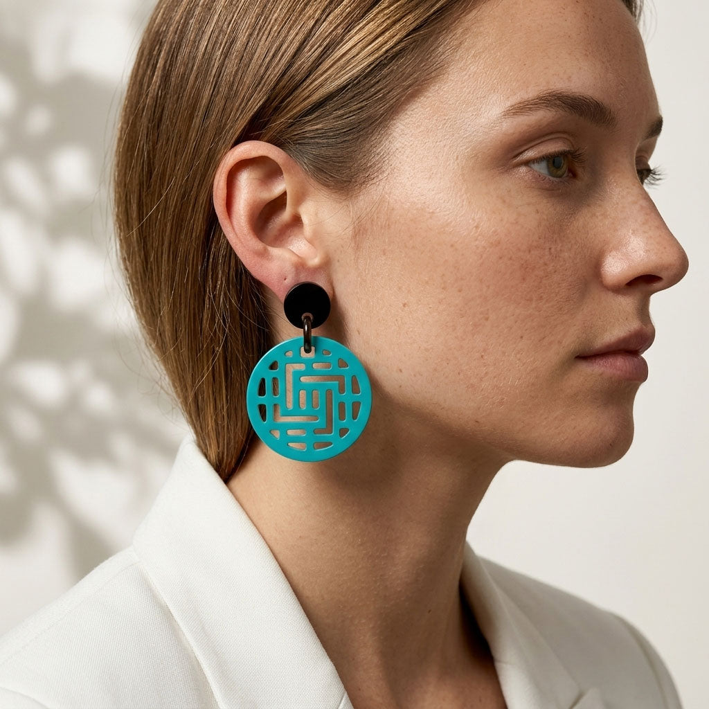 Woman wearing Branch Jewellery Moko turquoise round geometric pattern earrings with a neutral background