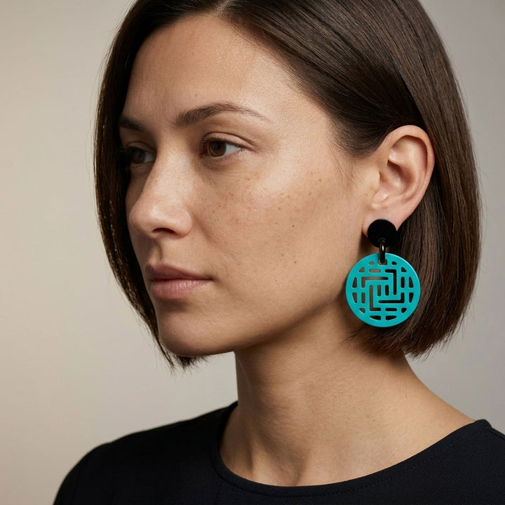 Woman wearing Branch Jewellery Moko turquoise round geometric pattern earrings with a neutral background