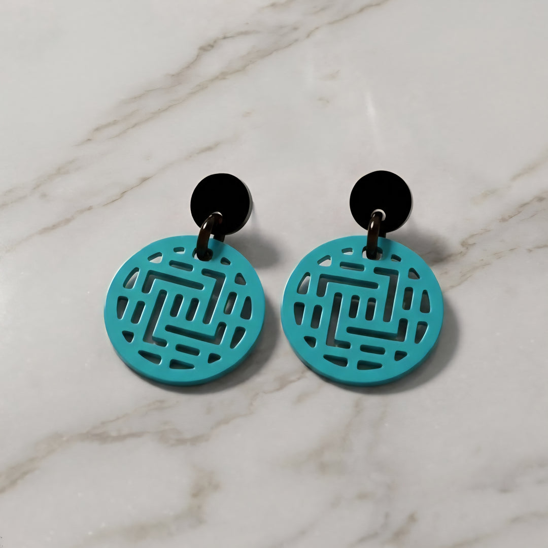 Branch Jewellery Moko round geometric patterned Turquoise earrings with black posts on a marble surface