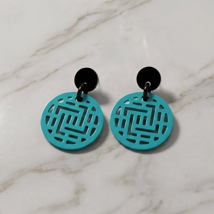 Branch Jewellery Moko round geometric patterned Turquoise earrings with black posts on a marble surface