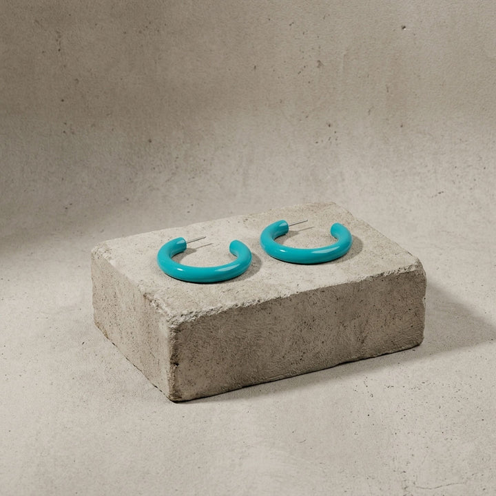 Branch Jewellery Turquoise hoop earrings on a concrete block with a neutral background