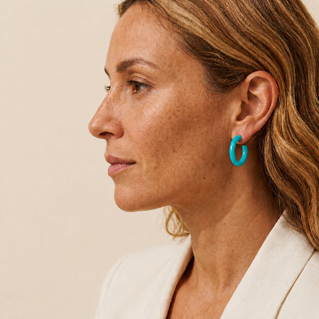 Branch Jewellery Rounded turquoise blue Lacquered horn hoop earrings, handcrafted with a glossy finish and featuring silver posts, are displayed against a white background.
