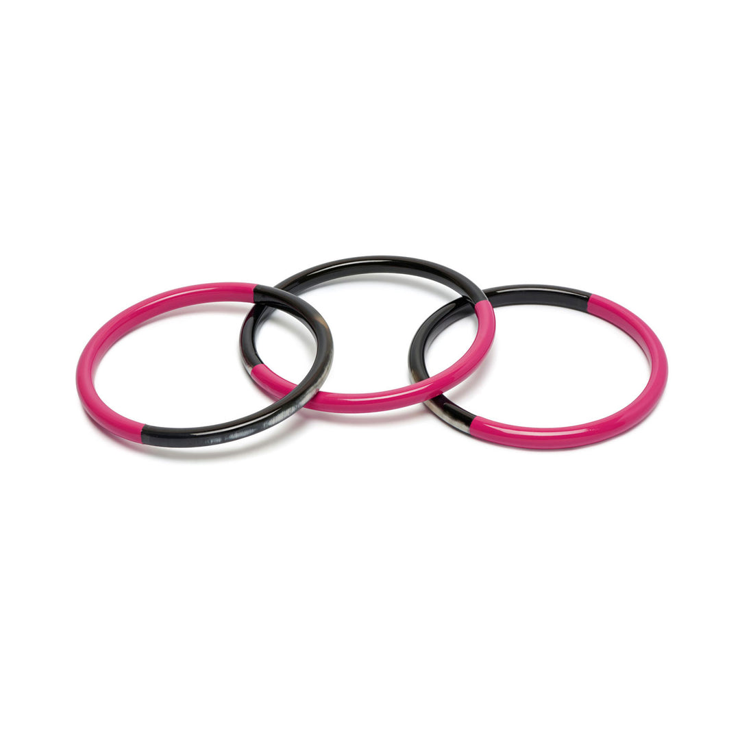 Branch Jewellery set of three slim rounded bangles made from naurtal buffalo horn and Fuchsia Pink lacquered horn.  Half of the bangle is black natural horn with natural markings and colourings and the other half is covered with a smooth fuchsia pink lacquer.